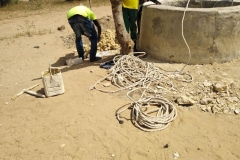 Um den Brunnen auszubauen, brachte der Brunnenbauer folgendes mit: nur eine lange, dünne Schnur, einen abgenutzten kleinen Eimer und einen… um zu graben.