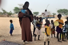 Der Vater nimmt stolz eins seiner Kinder auf den Arm.