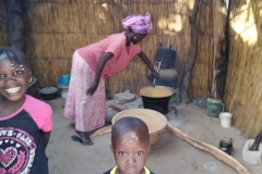 Es ist Essenszeit! Die Mama kocht und die Kinder leisten ihr Gesellschaft.