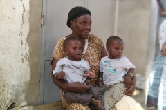 Die Oma hält die beiden Zwillinge für einen besseren Ausblick auf dem Schoß.